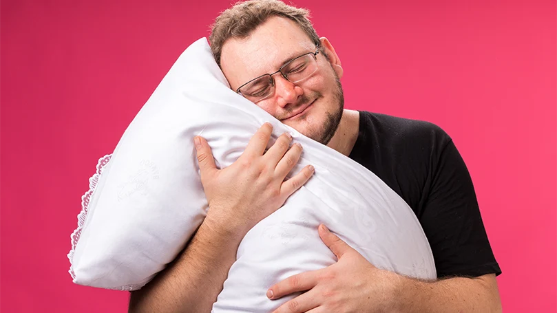 Una imagen de un hombre abrazando una almohada para respirar.