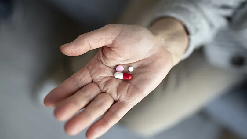 Imagen de un paciente mayor sosteniendo un medicamento para la enfermedad de Parkinson.